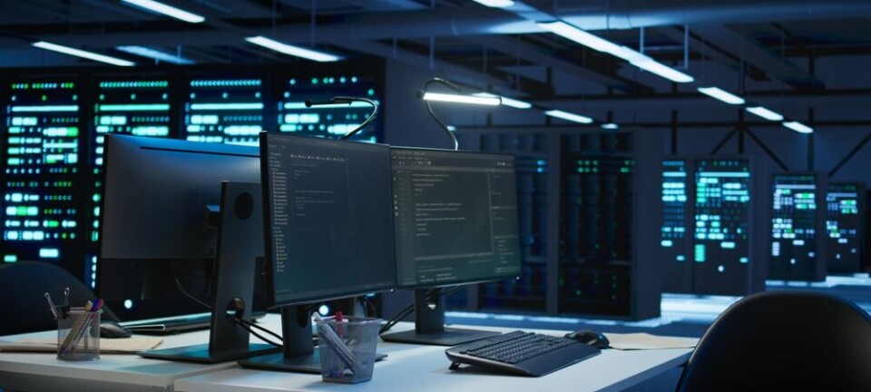 Dual-monitor workstation facing lit server racks in a business data center