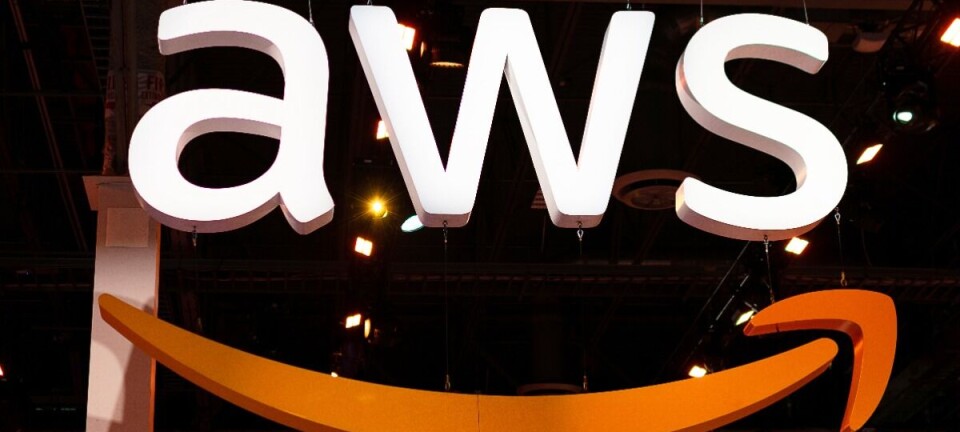 Large illuminated AWS logo with the orange smile arrow on a dark stage backdrop.