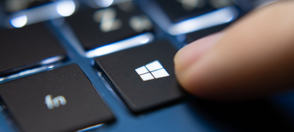 Close-up of a finger pressing the Windows key on a laptop keyboard.